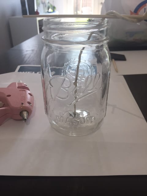 mason jar with a stick on top to hold the wick that has been glued in place