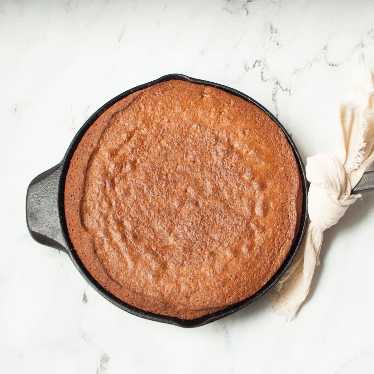 Cast Iron Skillet Banana Bread on a marble background.