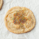 A close up photograph of a Great American Sugar cookie on a white background.