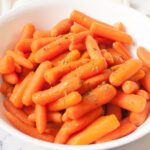 An upclose photograph of Copycat Cracker Barrel carrots in a white bowl.