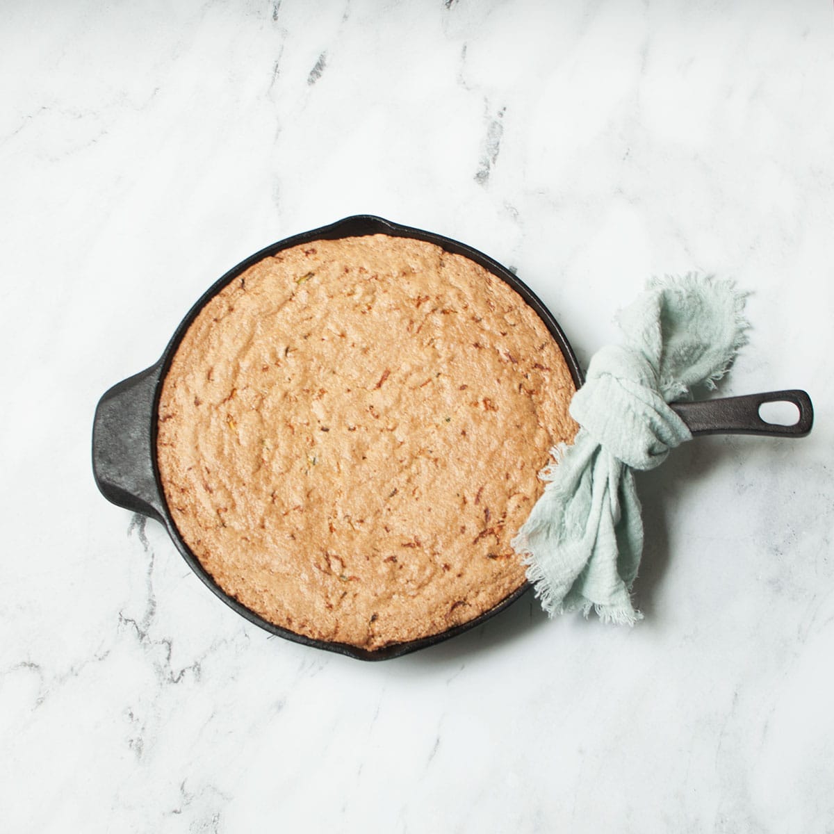 Cast Iron Skillet Zucchini Bread on a marble background.