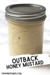Text that says copycat Outback honey mustard behind the text is an image of honey mustard in mason jar.