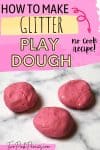 text that says how to make glitter paly dough no cook recipe below is an image of pink glitter play dough balls on a white marble background.