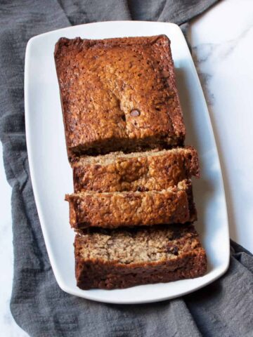 loaf of Chocolate Chip Oatmeal Banana Bread on a white rectangular plate