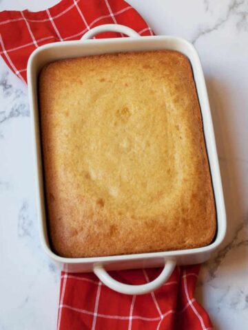 Yellow Cake Mix Corn Bread in a white pan with a red tea towel