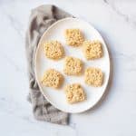 Rice Crispy Treats made with Jumbo Marshmallows on a white oval plate with a gray linen