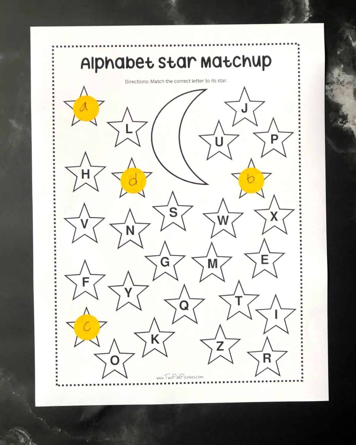 The dot sticker printable with a few dot stickers that have been labeled with letters. 