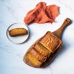 Amish Pumpkin Bread on a wooden board with an orange napkin