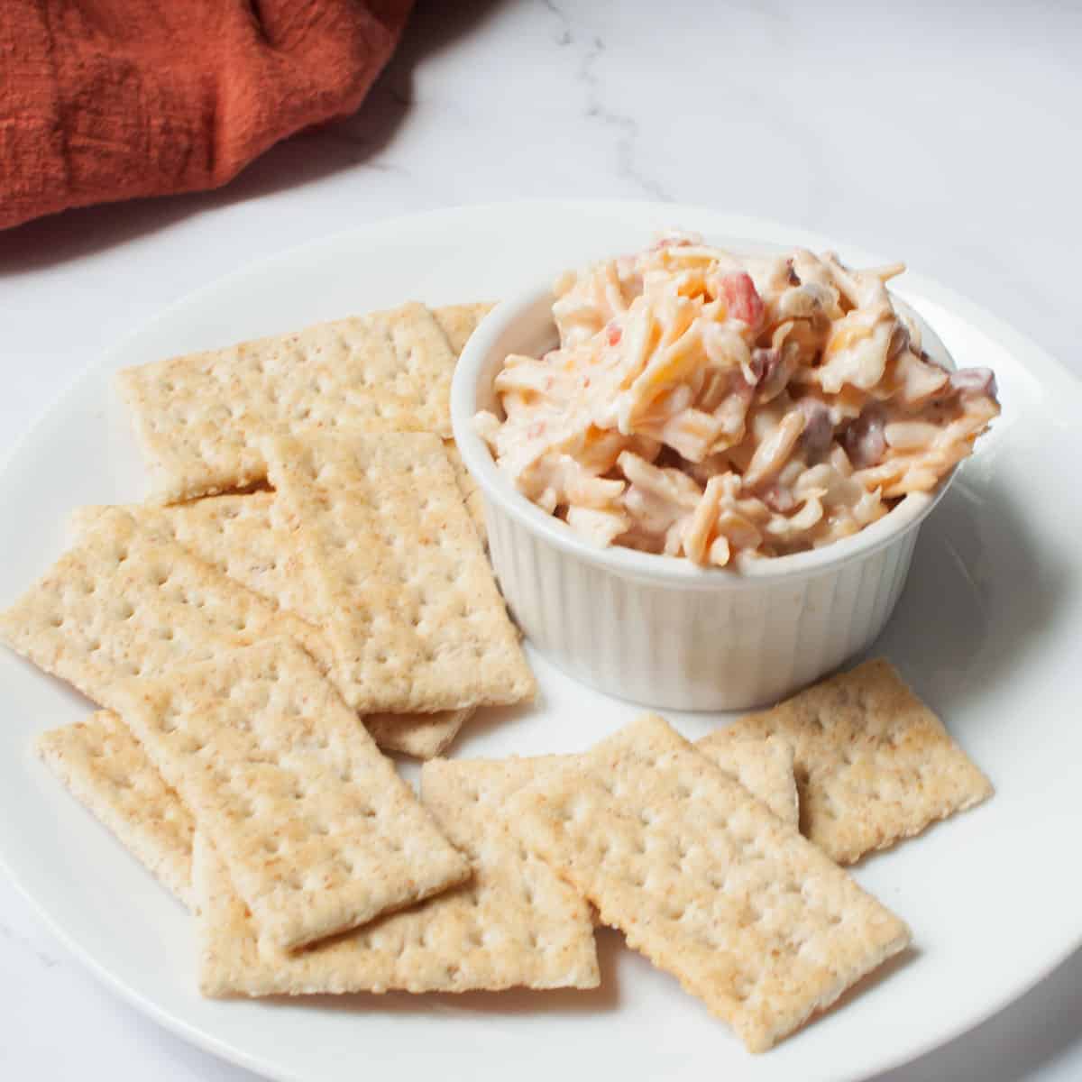 a small bowl of pimento cheese surrounded by crackers