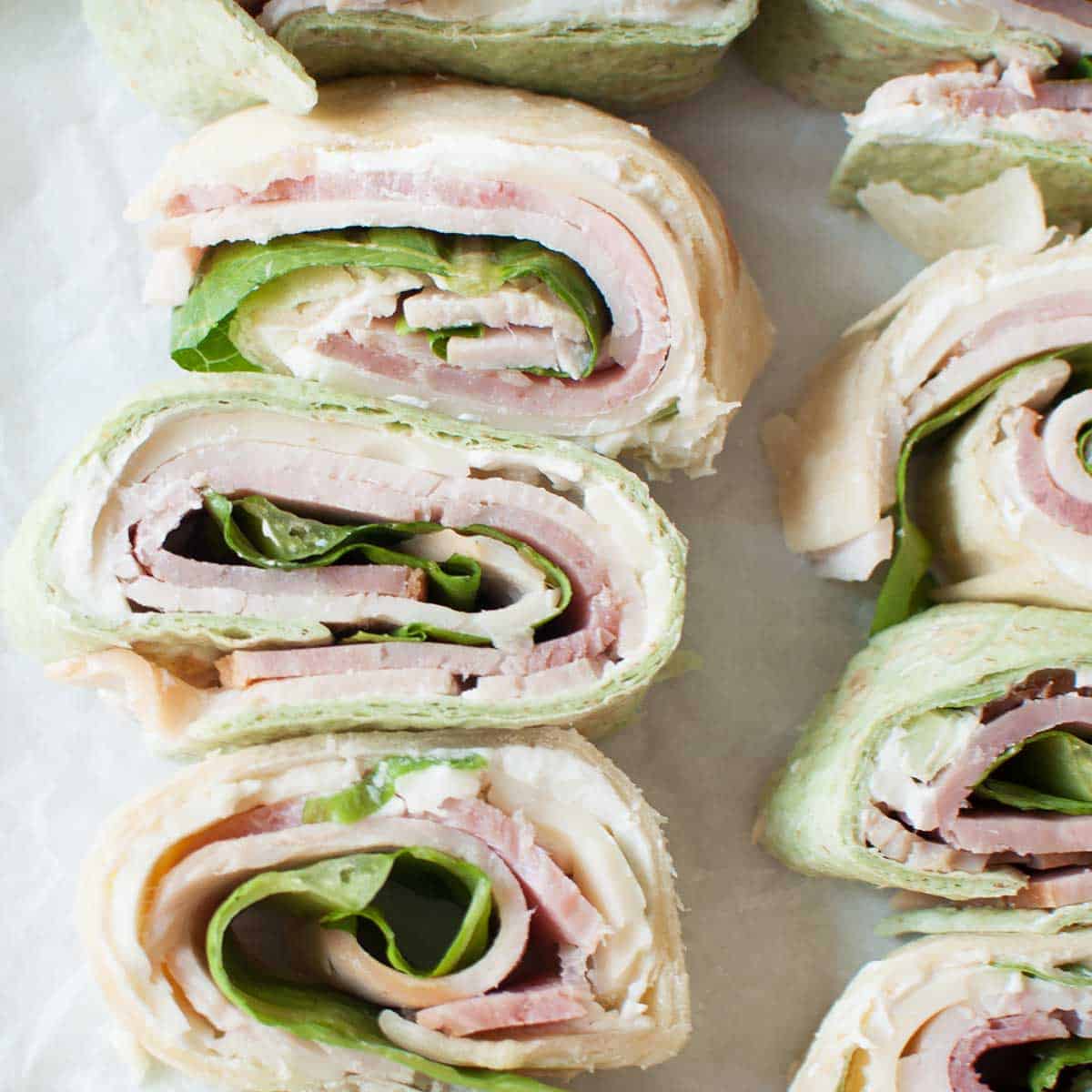 pin wheel sandwiches (sandwiches made from tortillas, lunch meat, cream cheese mixture, and lettuce)