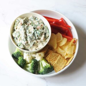 Lipton spinach dip with vegetables, chips and crackers around it