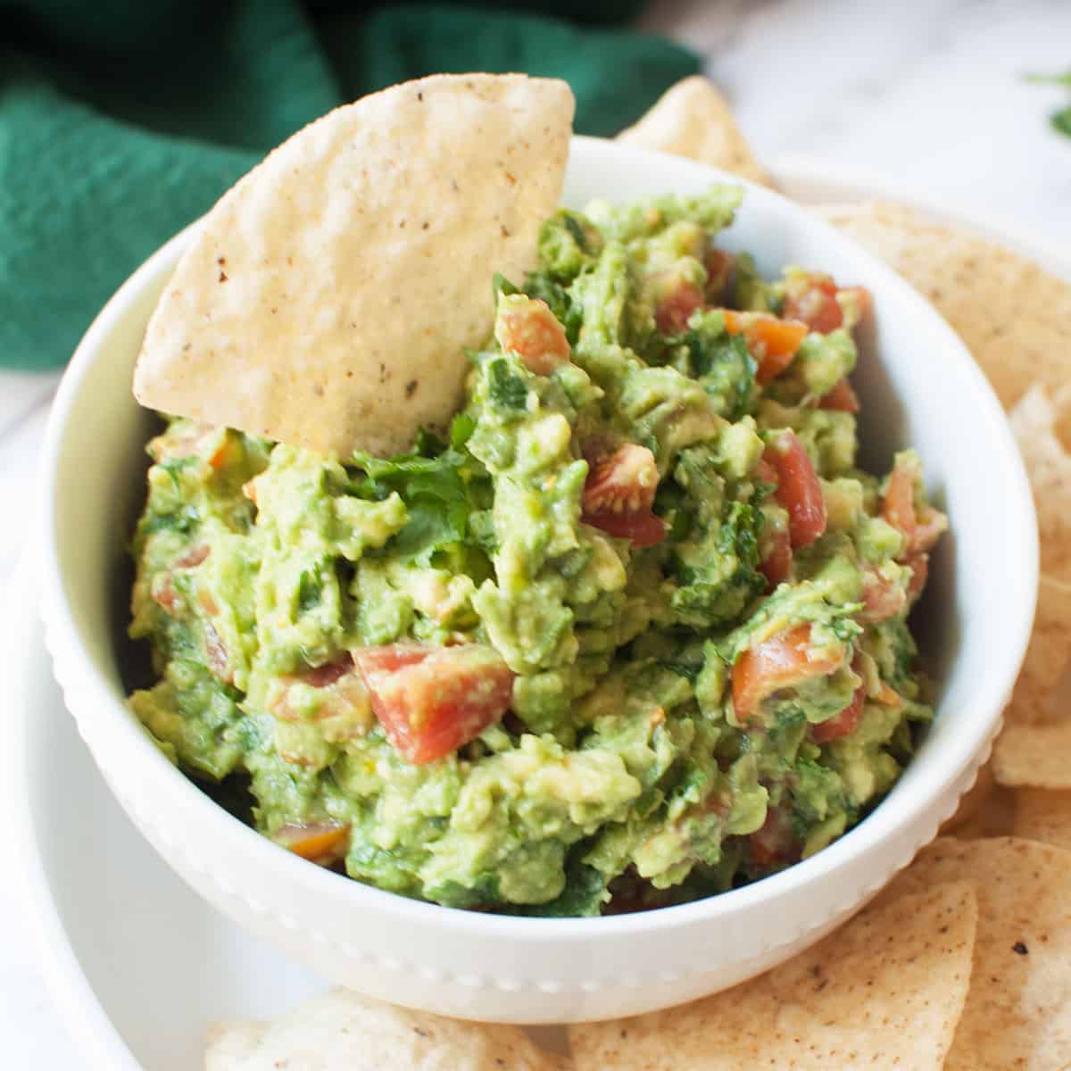 bowl of guacamole with a chip in it