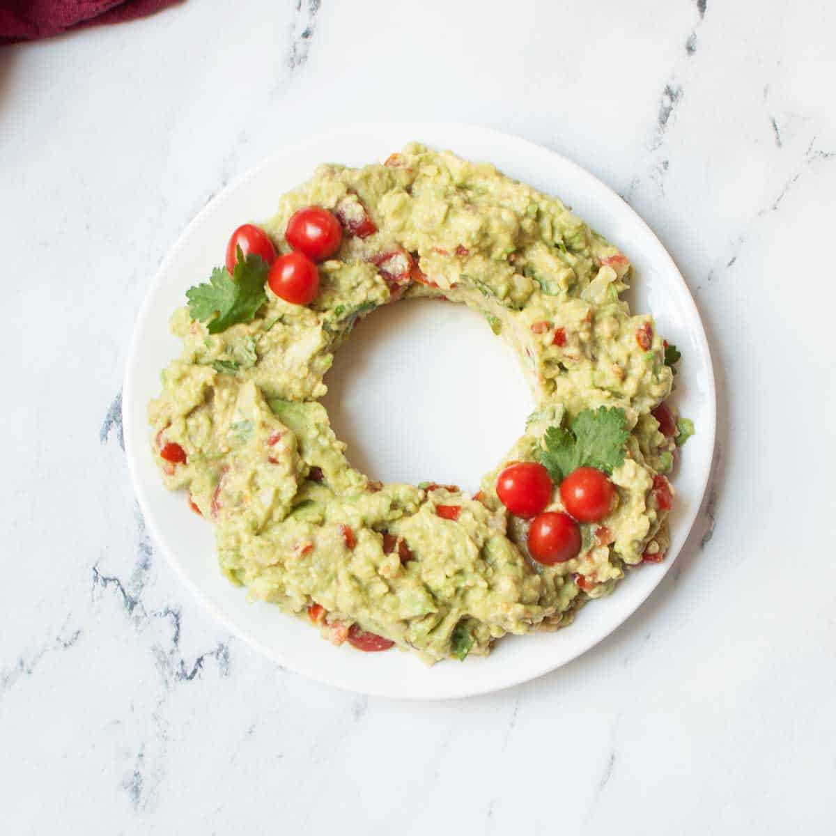 guacamole on a plate in the shape of a Christmas wreath