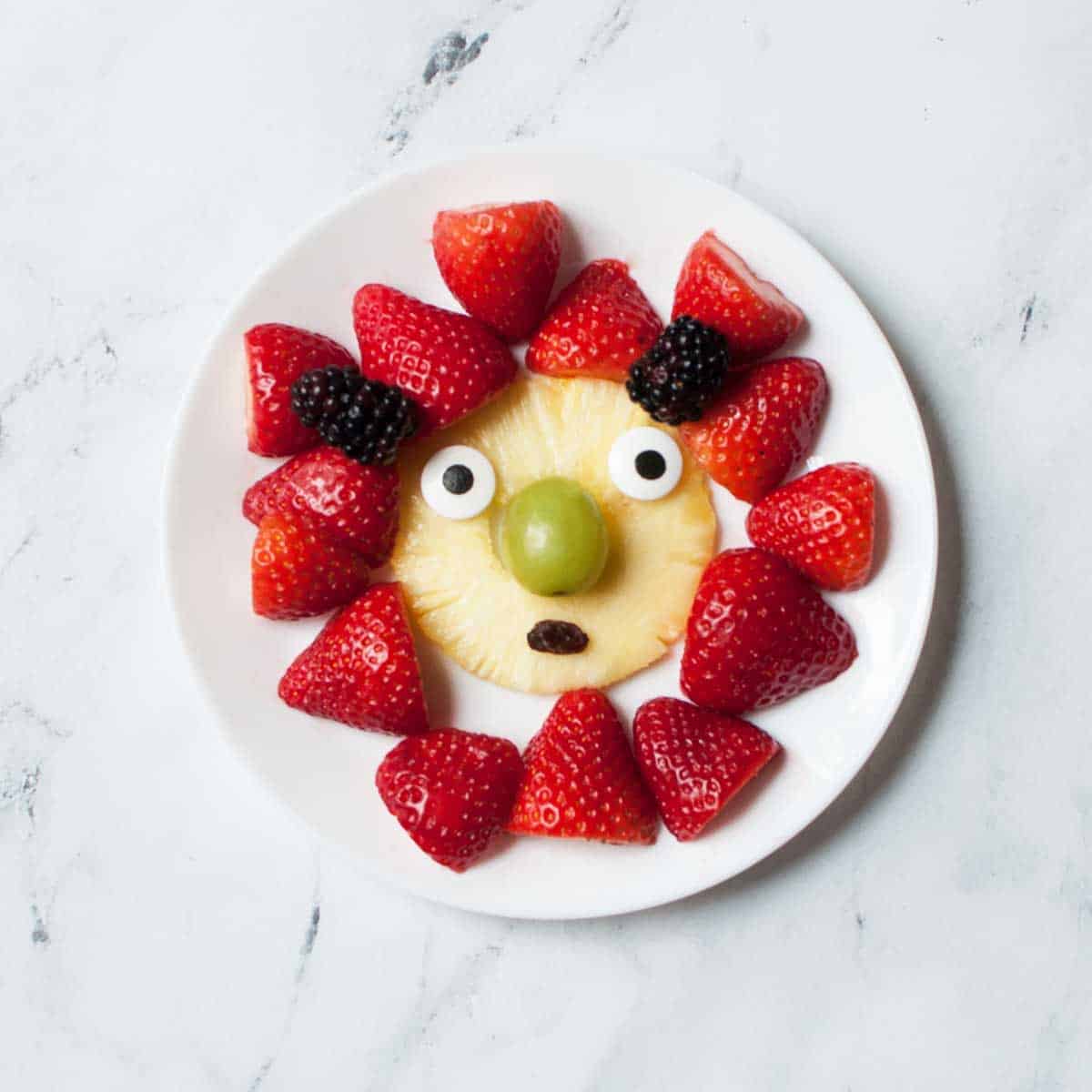 a plate of fruit arranged to look like a monster 