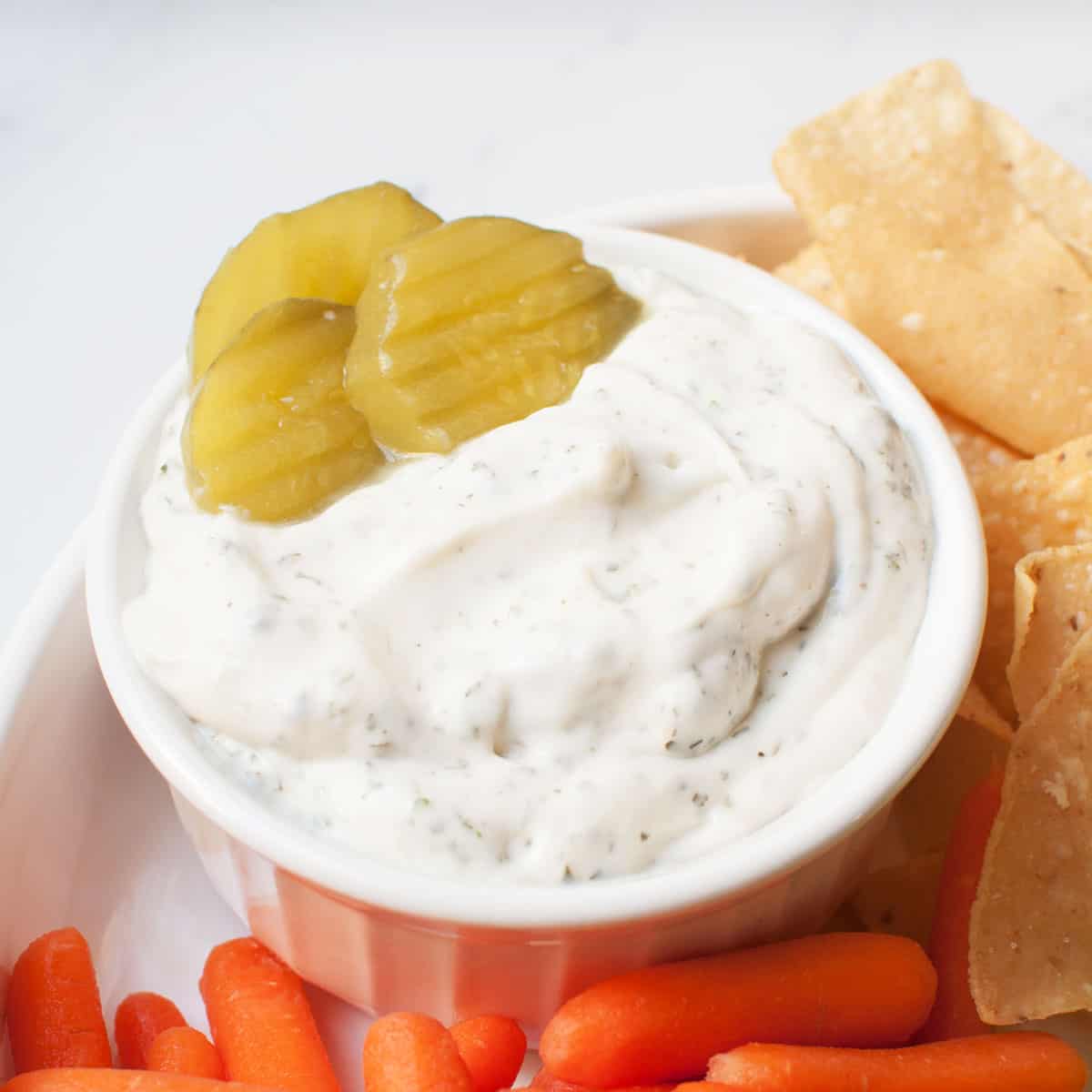 small bowl of ranch with pickles in it