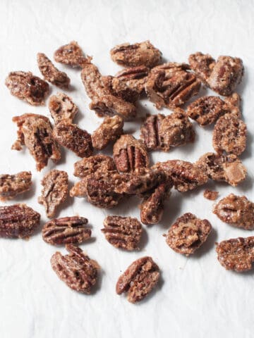 Copycat Buc-ees pecans (roasted pecans with cinnamon sugar) on a white background.