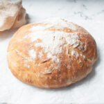 A loaf of sourdough bread dusted with flour.