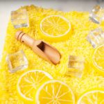 A lemonade sensory bin (rice dyed yellow with toy lemon slices, ice cubes and wooden scoops).