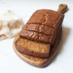 old fashioned zucchii bread sliced on a wooden tray with a cream linen.
