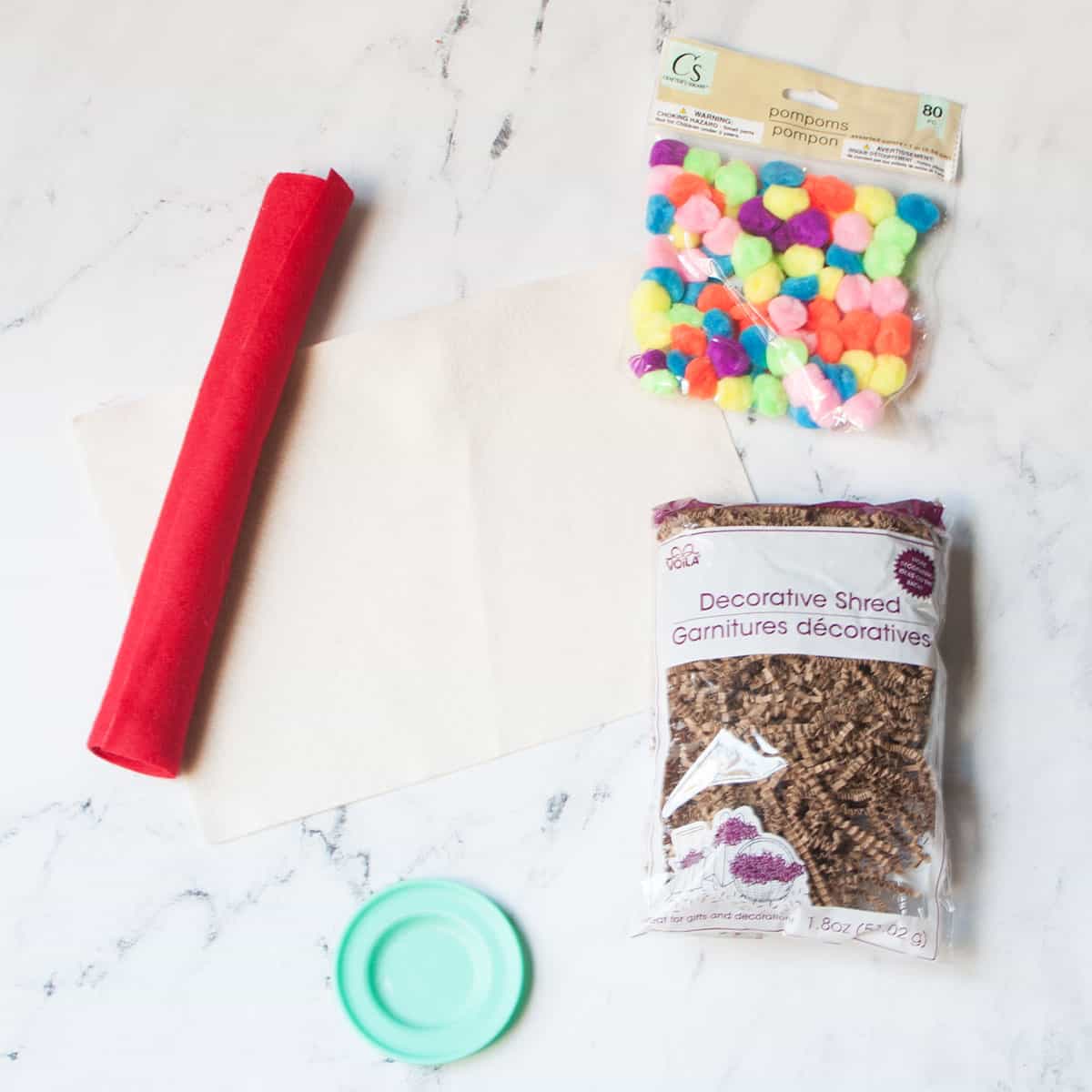 The supplies needed to make a pizza sensory bin.