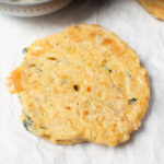 Sourdough zucchini fritter on a white background.