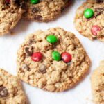 A Christmas monster cookie (a monster cookie with red and green M&Ms) on a white background.