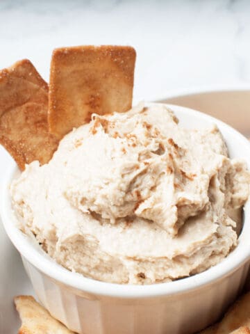 Close up view of a cream cheese based dip with cinnamon sugar chips in it.