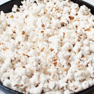 Up close view of popcorn made in a cast iron skillet.