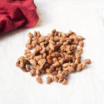 Christmas Almonds on white parchment paper with a red linen to the side.