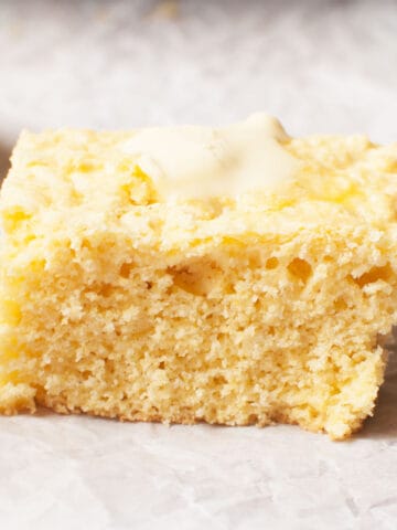 A slice of cornbread with butter on top.