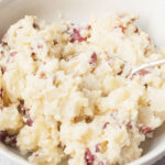 Copycat Carrabbas Mashed Potatoes with a spoon scooping them.