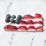 A flag graham cracker snack on a white marble background.