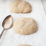 Sourdough banana cookies on a white background with a spoon with icing on it.