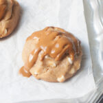 A cookie butter cookie sitting on a silver tray with white parchment paper.