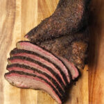 Copycat Buc-ee's Brisket sliced on a wooden board.