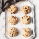 Jumbo Oatmeal cookies on a tray with a gray linen behind them.