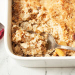 A spoon scooping copycat Cheesecake Factory Apple Crisp.