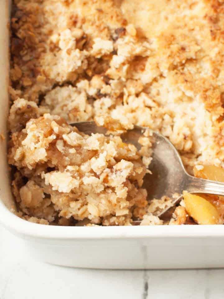 A spoon scooping copycat Cheesecake Factory Apple Crisp.
