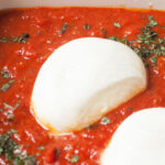 An up close photograph of baked burrata.
