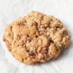 A close up photo of a copycat ChopShop Oatmeal Cookie on a white background.