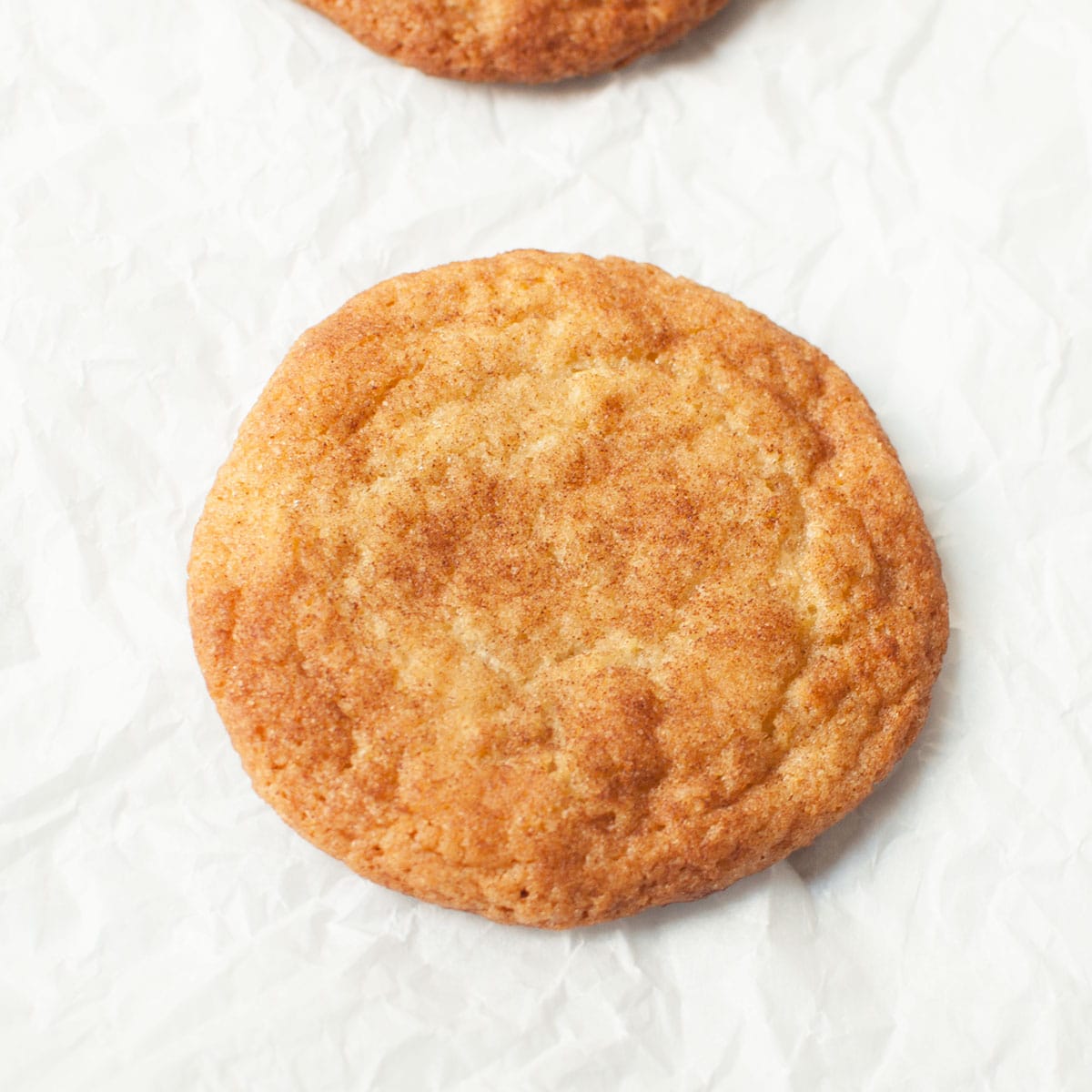 A copycat Great American Cookies Snickerdoodle cookie on a white background.