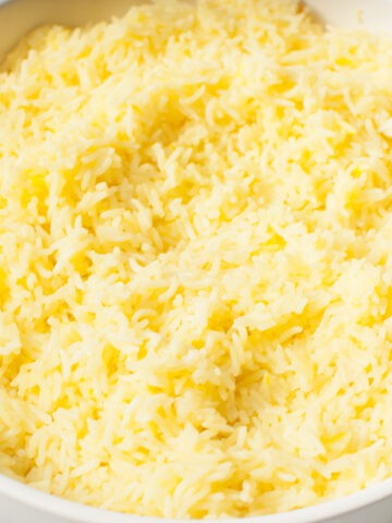 An up close photograph of Copycat Cava Saffron Rice in a white bowl.