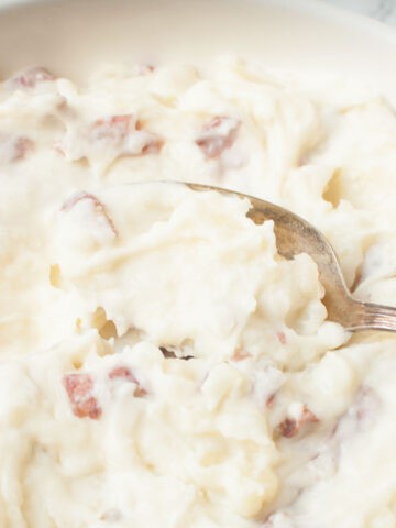 A spoon scooping Copycat Cheesecake Factory Mashed Potatoes.