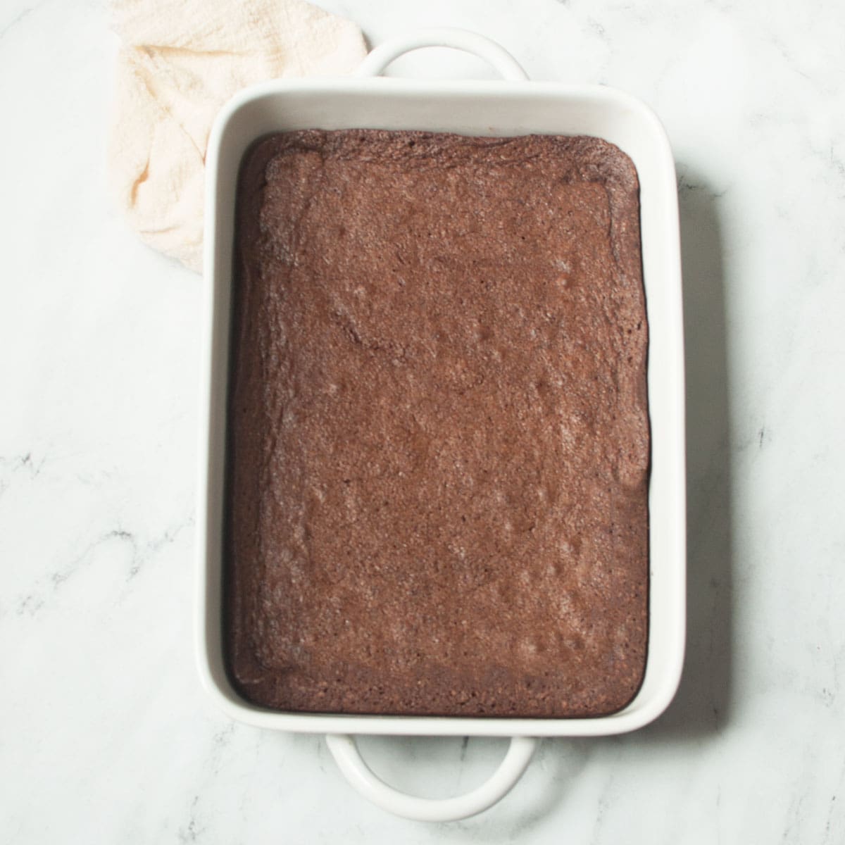 Amish brownies in a 9 x 13 inch pan on a marble background.