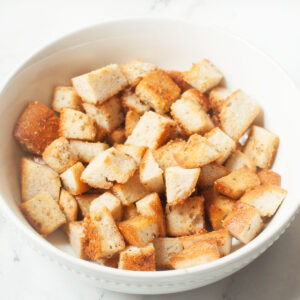 Copycat Texas Roadhouse croutons in a white bowl on a marble background.