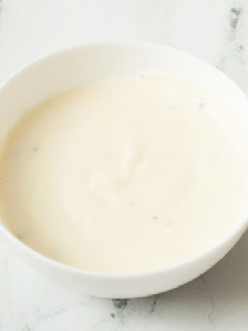 Copycat Texas Roadhouse White Gravy in a white bowl on a marble background.