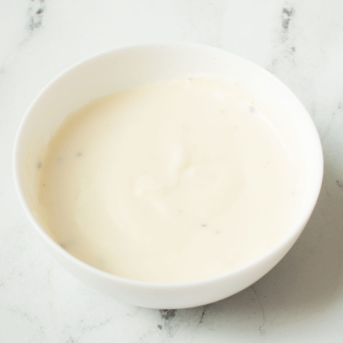 Copycat Texas Roadhouse White Gravy in a white bowl on a marble background.
