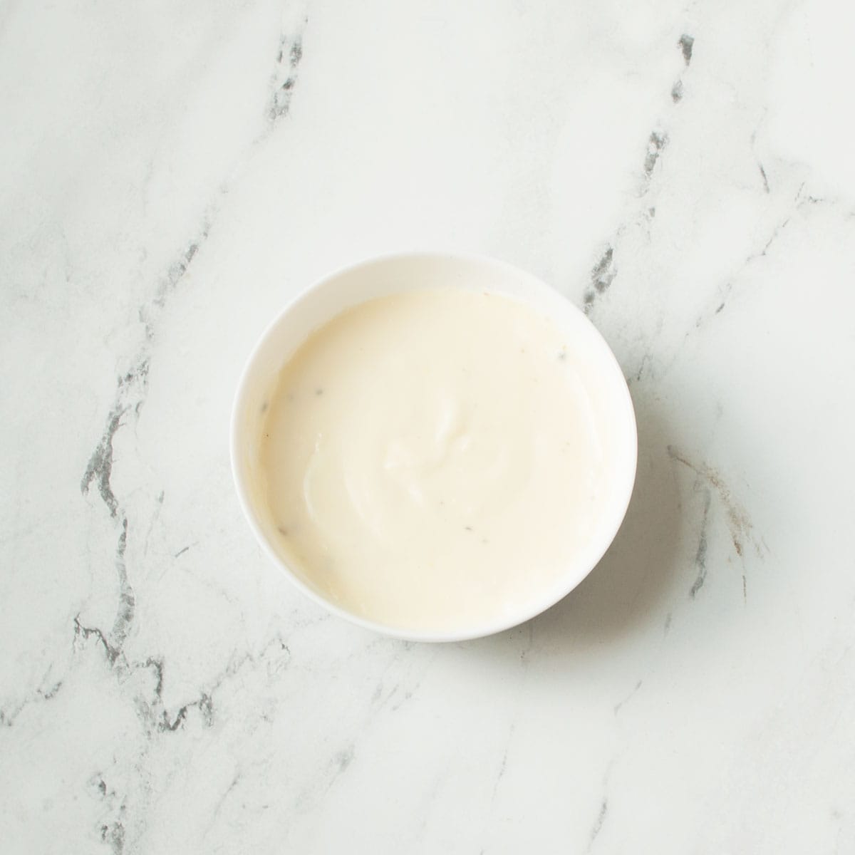 Copycat Texas Roadhouse White Gravy in a white bowl on a marble background.