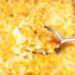 A spoon scooping corn pudding.