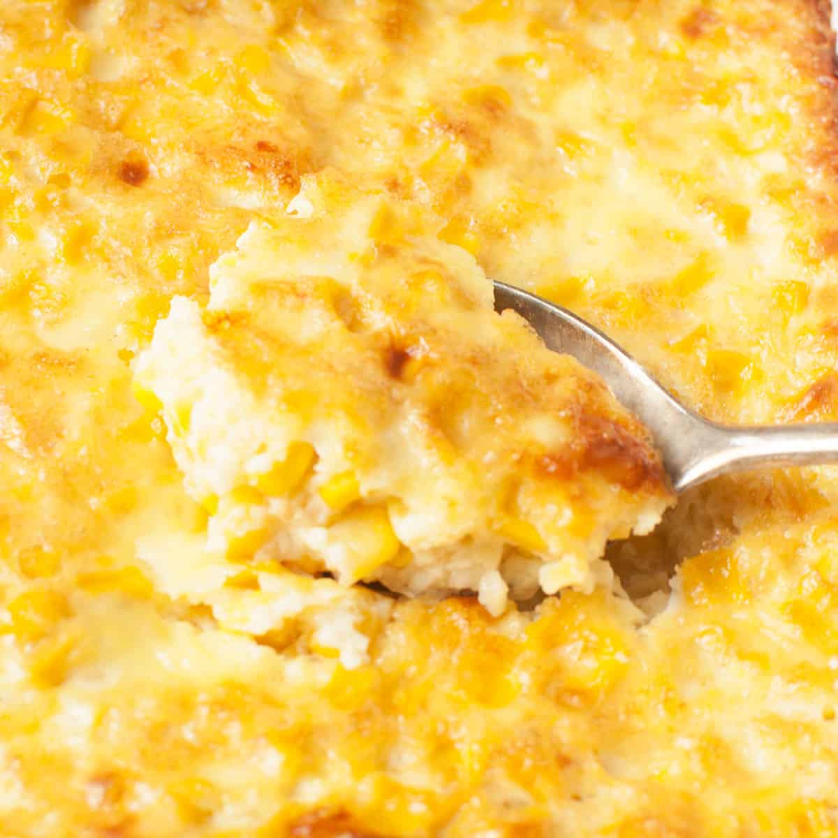A spoon scooping corn pudding.